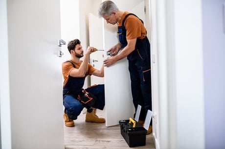 Deux serruriers ouvrant une porte