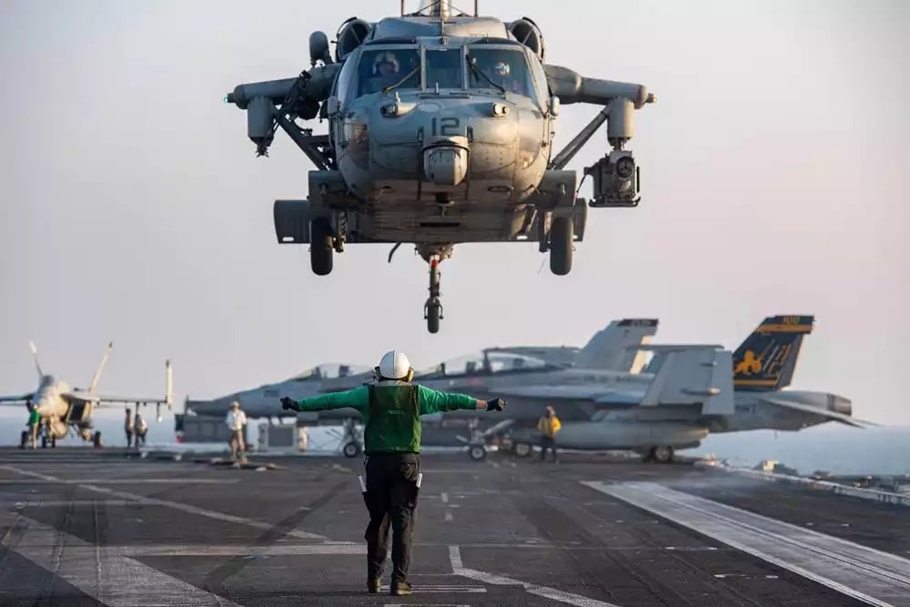 MH-60S Knighthawk (équipé d'un canon triple M197 de 20 mm) au-dessus du pont d'envol du porte-avions USS Dwight D. Eisenhower (CVN-69).