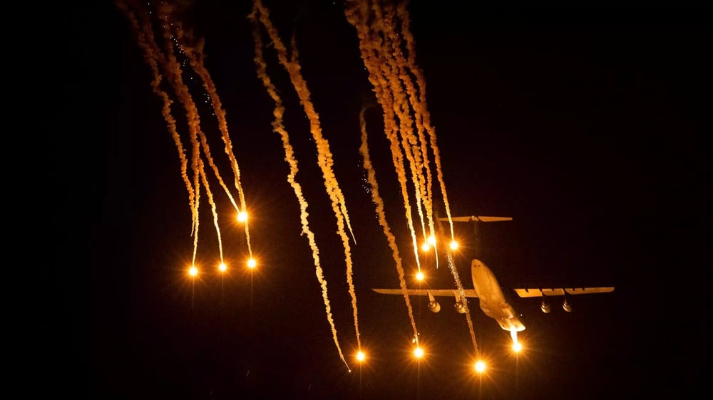 C-5M Super Galaxy larguant des leurres infrarouges durant un essai de nuit au-dessus de la base aérienne d'Eglin (Floride).