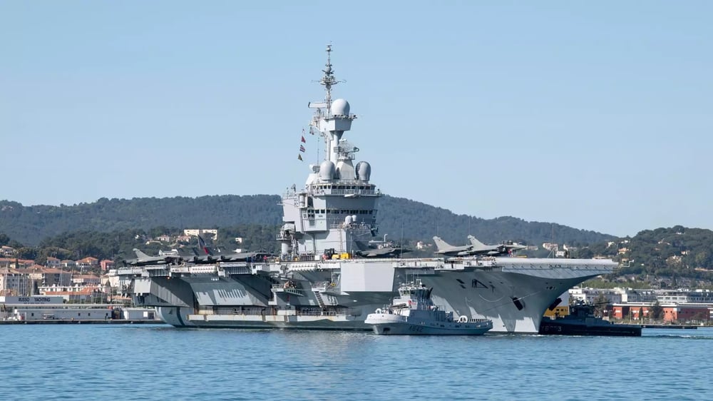 Appareillage du porte-avions Charles de Gaulle depuis Toulon pour la mission Akila (23 avril 2024). Des Rafale M et un E-2C Hawkeye sont visibles sur le pont d'envol.