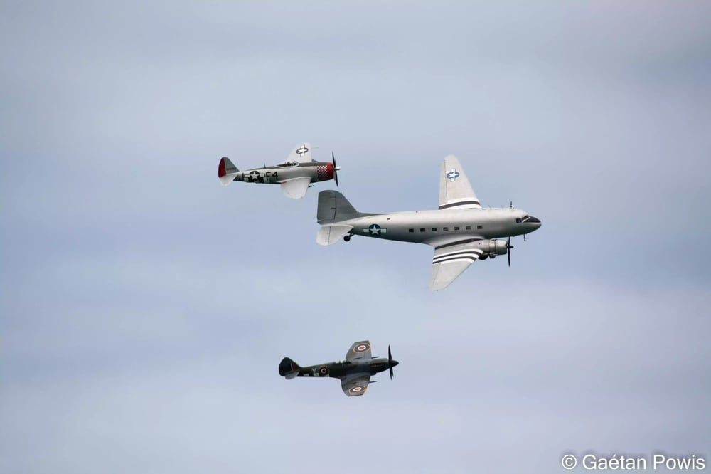 Ouverture du meeting aérien d'Arromanches par une patrouille mixte composée d'un Spitfire Mk XIV, un DC-3 Dakota et un P-47D Thunderbolt (8 juin 2024).