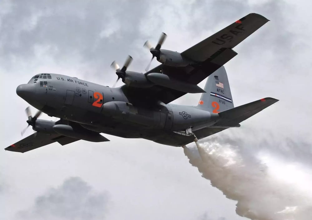 Avion de transport tactique C-130H Hercules de l'US Air Force Reserve Command larguant de l'eau grâce à un MAFFS I lors d'un entrainement.