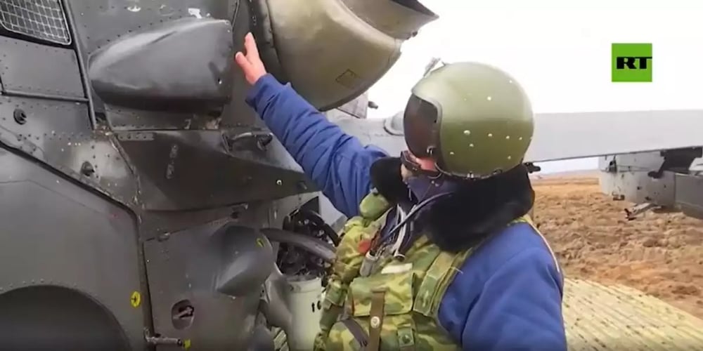 Le pilote montre les impacts de balles sur l'arrière du moteur endommagé.