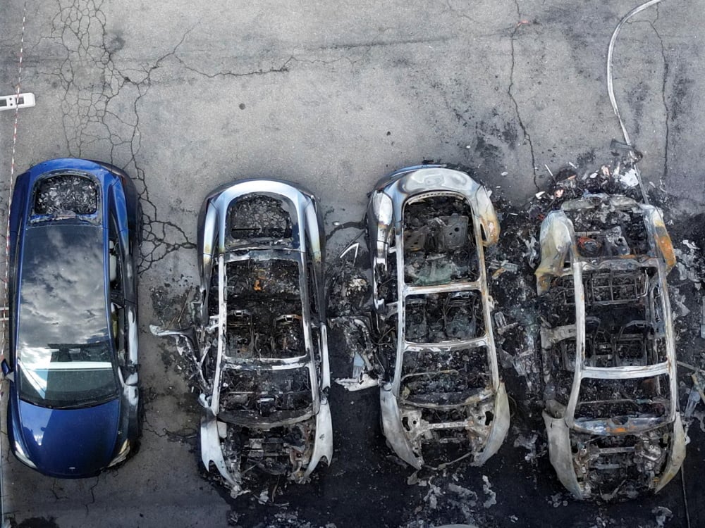 Des véhicules Tesla calcinés après un incendie dans une concession Tesla à Rome, en Italie.