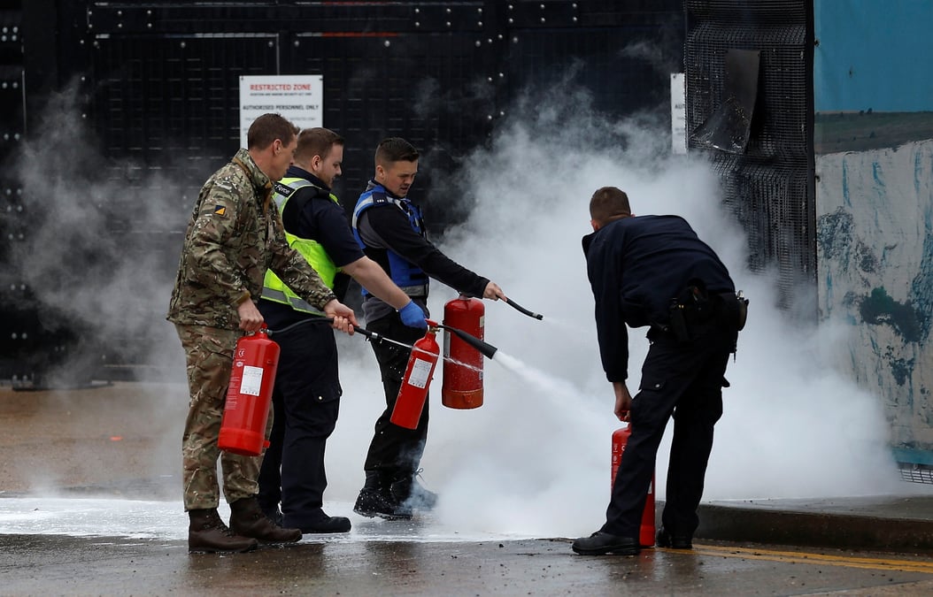 Du personnel militaire et des membres des services d'immigration britanniques eteignent un incendie apres une attaque contre des locaux des services d'immigration