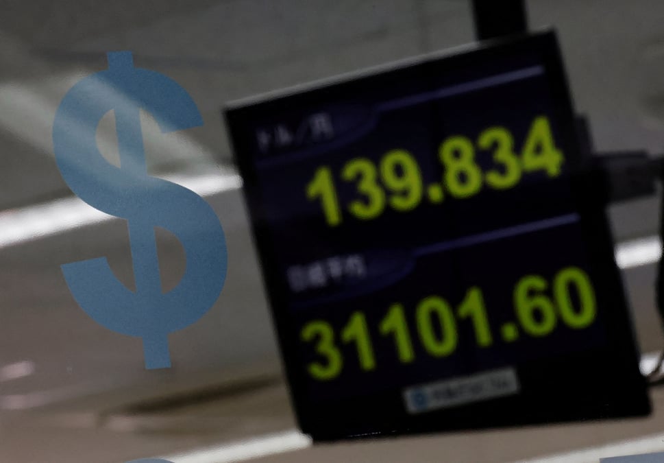 Un logo du dollar americain et la valeur du yen a la societe d'echange de devises gaitame.com a tokyo