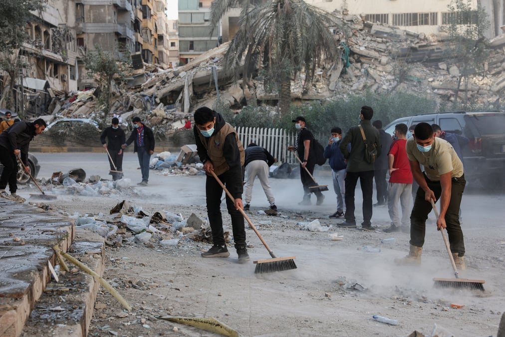 Des membres des scouts de l'imam al-mahdi nettoient les decombres et les debris des batiments endommages dans les banlieues sud de beyrouth