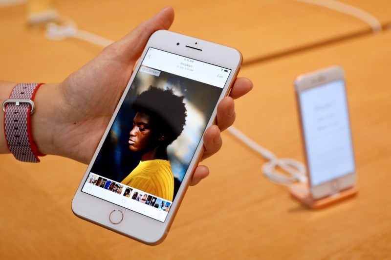 Un employe d'apple presente un iphone 8 plus dans une boutique du groupe a singapour