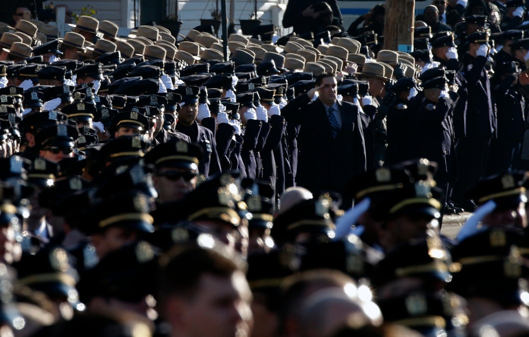 Police salute during the playing of the u.s. national anthem outside the christ tabernacle church at the start of the funeral service for slain nypd officer ramos in the queens borough of new york