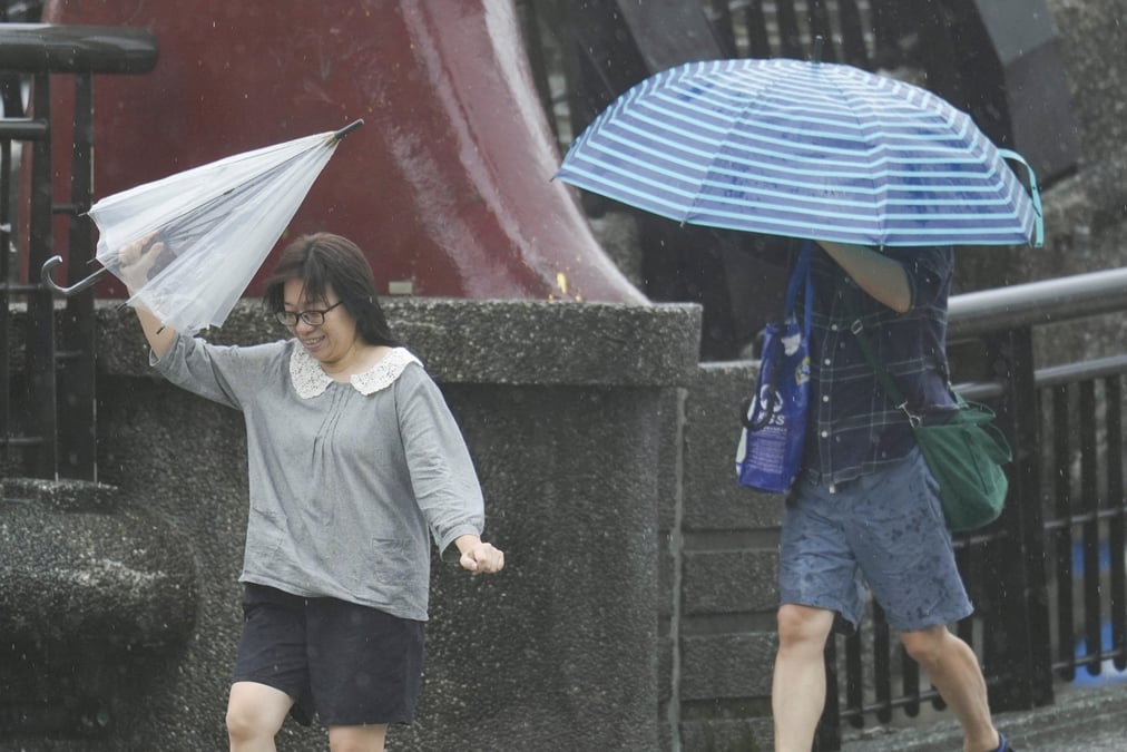 Des personnes tiennent des parapluies alors que le typhon kong-rey approche a keelung