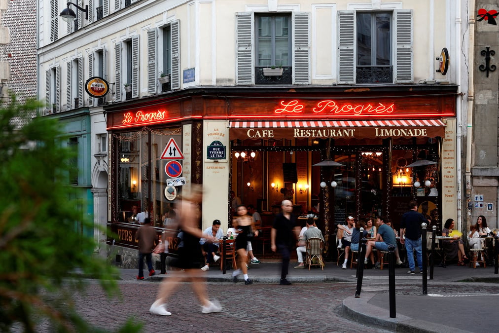 Des gens passent devant un restaurant a paris