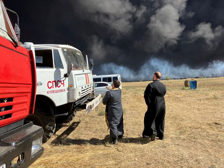 Des clercs orthodoxes russes arrosent de l'eau benite sur des camions de pompiers suite a une attaque de drone