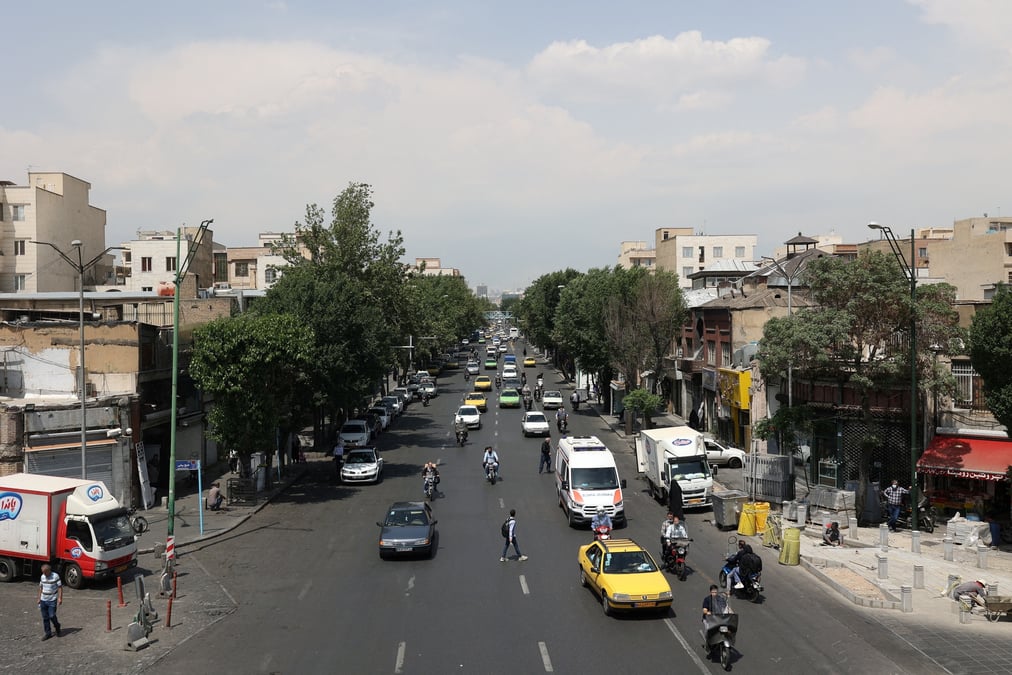 Des voitures roulent dans une rue de teheran
