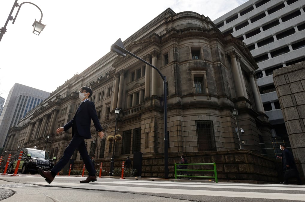 Photo d'un homme qui marche devant le siege de la banque du japon a tokyo