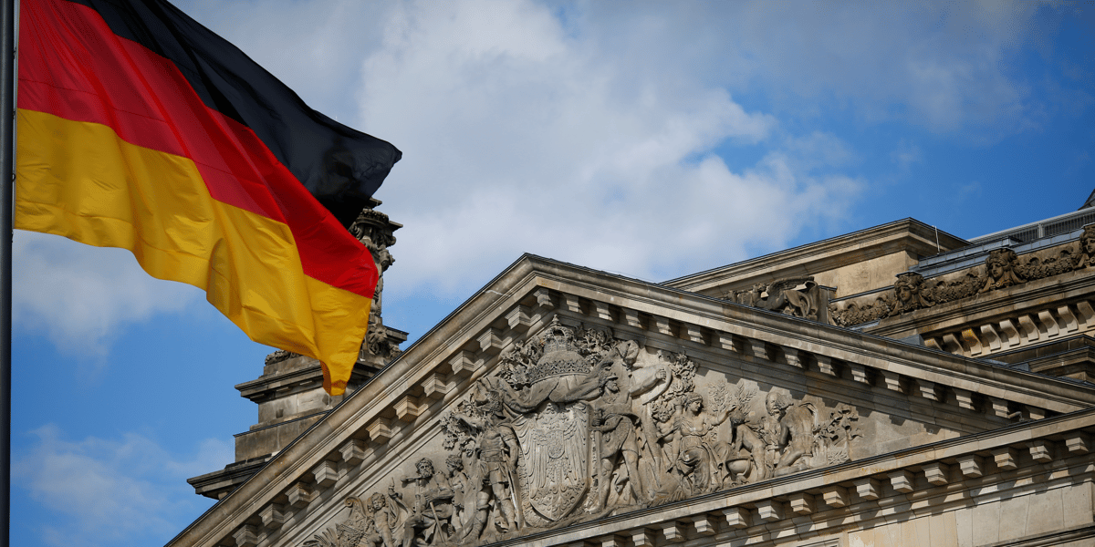 Un drapeau allemand flotte devant le batiment du reichstag a berlin, allemagne