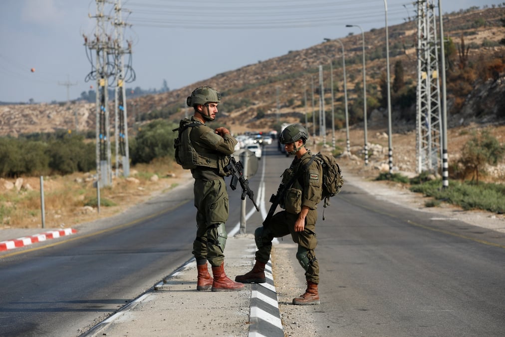 Les forces israeliennes montent la garde pres d'une scene de fusillade, pres de hebron dans la cisjordanie