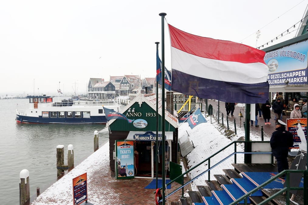 Un drapeau neerlandais flotte dans le port de volendam pres d'amsterdam