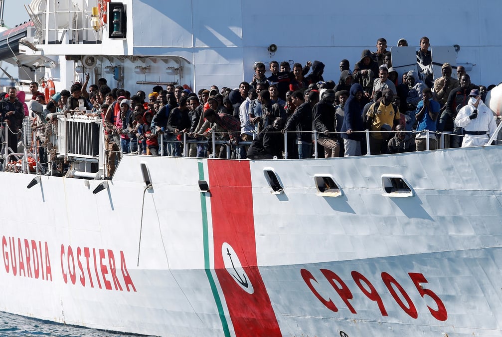 Des migrants arrivent par le peluso, navire des garde-cotes italiens, dans le port sicilien d'augusta