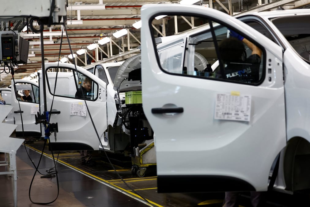 Des employes travaillent sur une chaine de montage automobile
