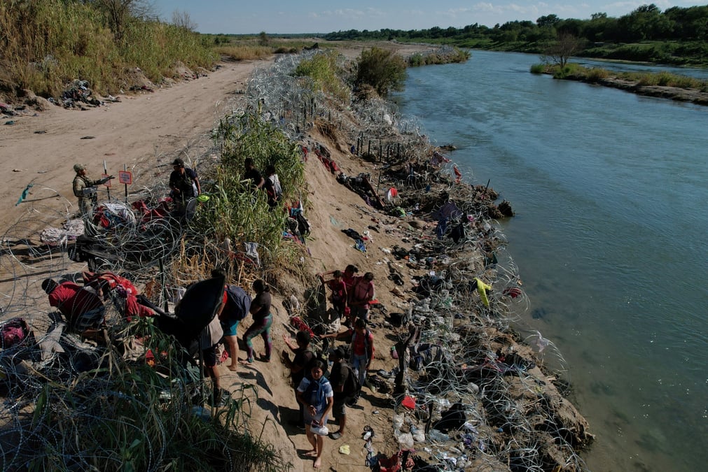 Des membres de la garde nationale du texas tentent de dissuader les migrants de franchir les barbeles apres avoir traverse le rio grande
