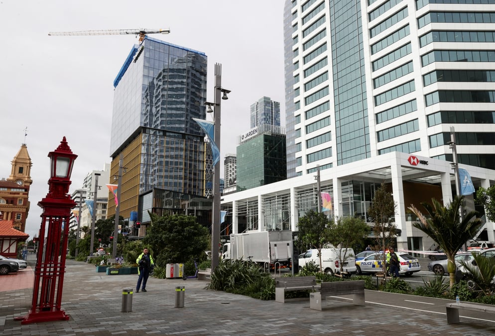 Des policiers armes montent la garde pres d'un chantier de construction apres une fusillade a auckland