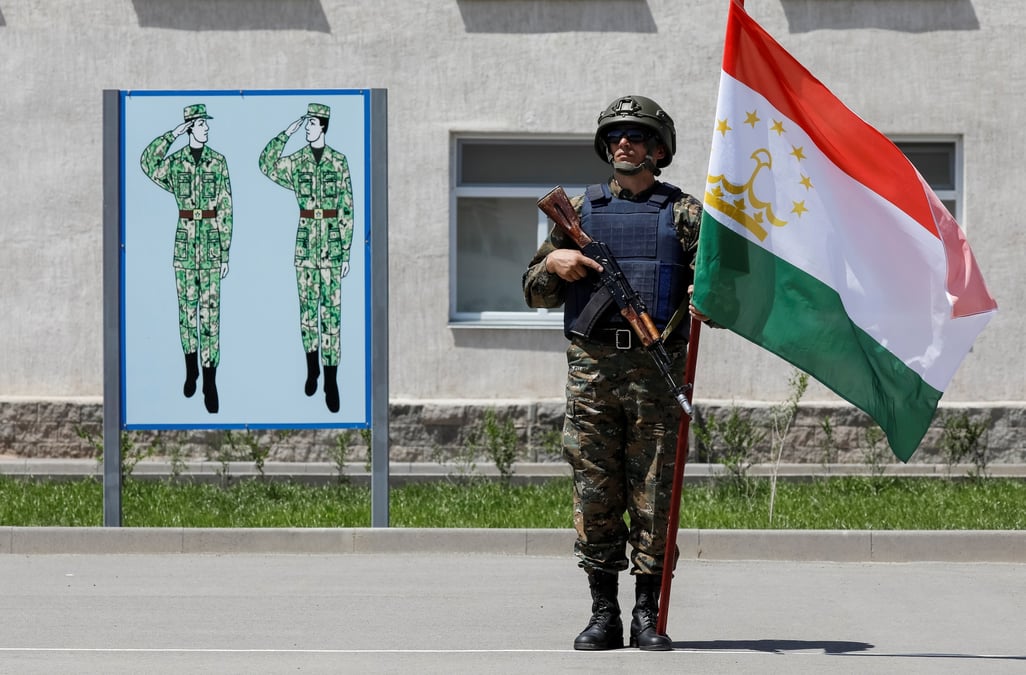 Photo d'archives d'un soldat tenant un drapeau du tadjikistan lors d'exercices militaires pres d'almaty, au kazakhstan