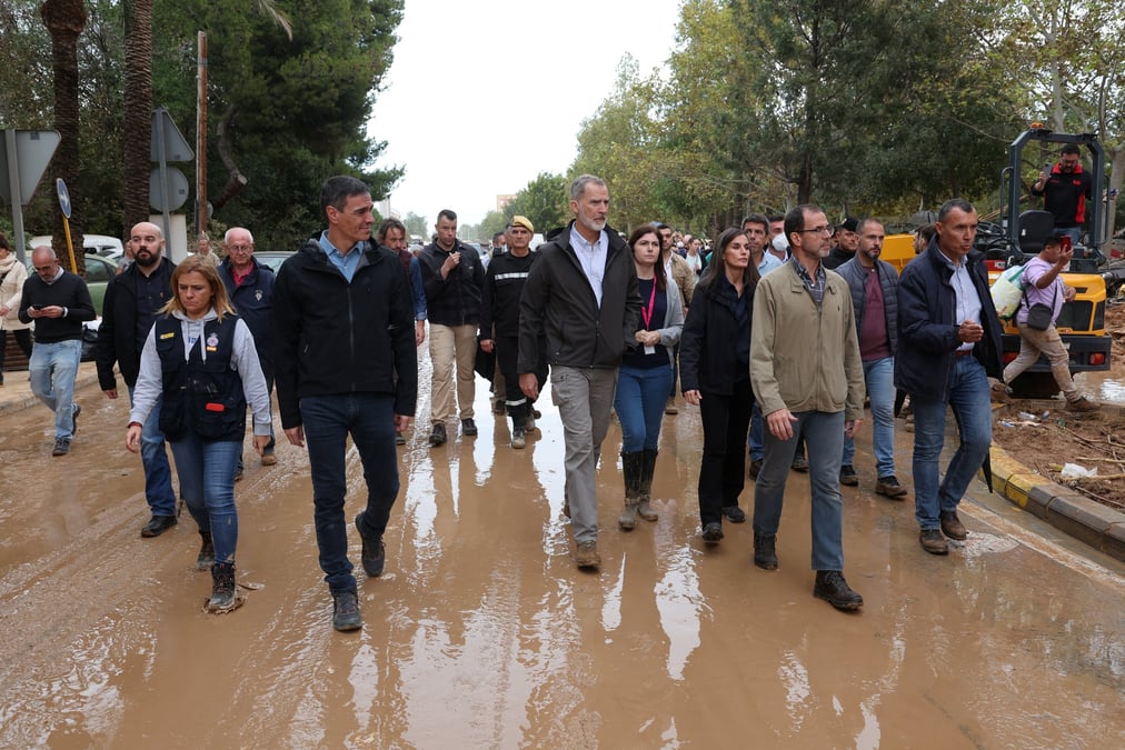 Le premier ministre espagnol pedro sanchez, le roi felipe d'espagne et la reine letizia marchent dans une rue boueuse a leur arrivee pour visiter les zones affectees par les inondations