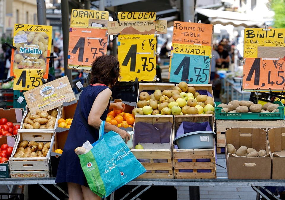 Photo d'archives : des etiquettes de prix sont visibles alors qu'une femme fait ses courses sur un marche local a nice