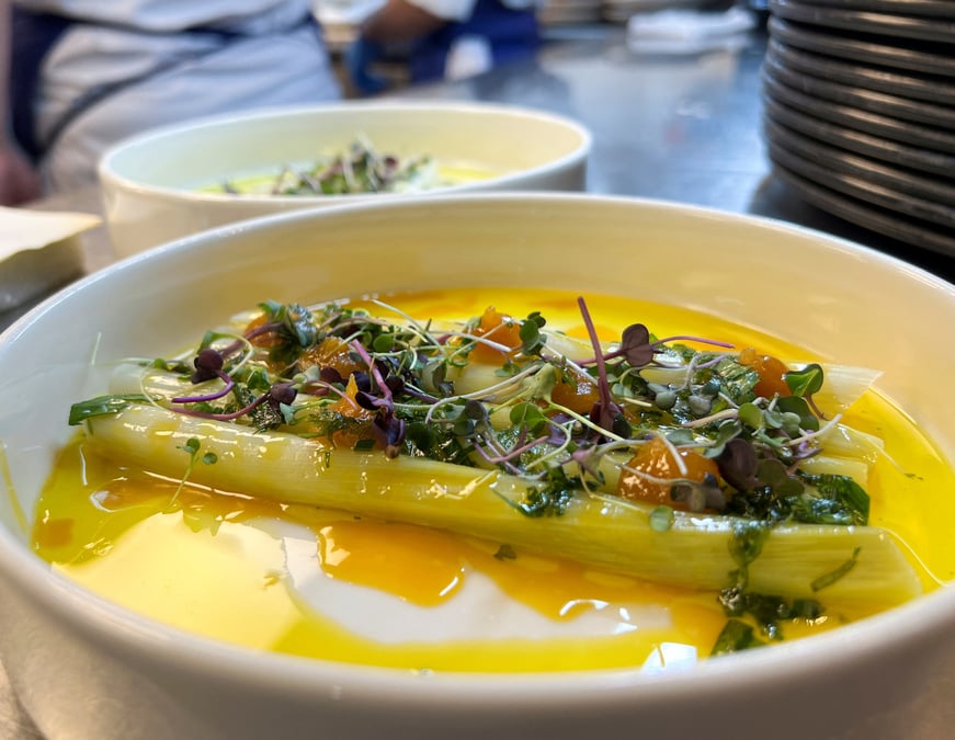 Une assiette de poireaux braises chez madame brasserie, le restaurant ouvert par thierry marx a la tour eiffel