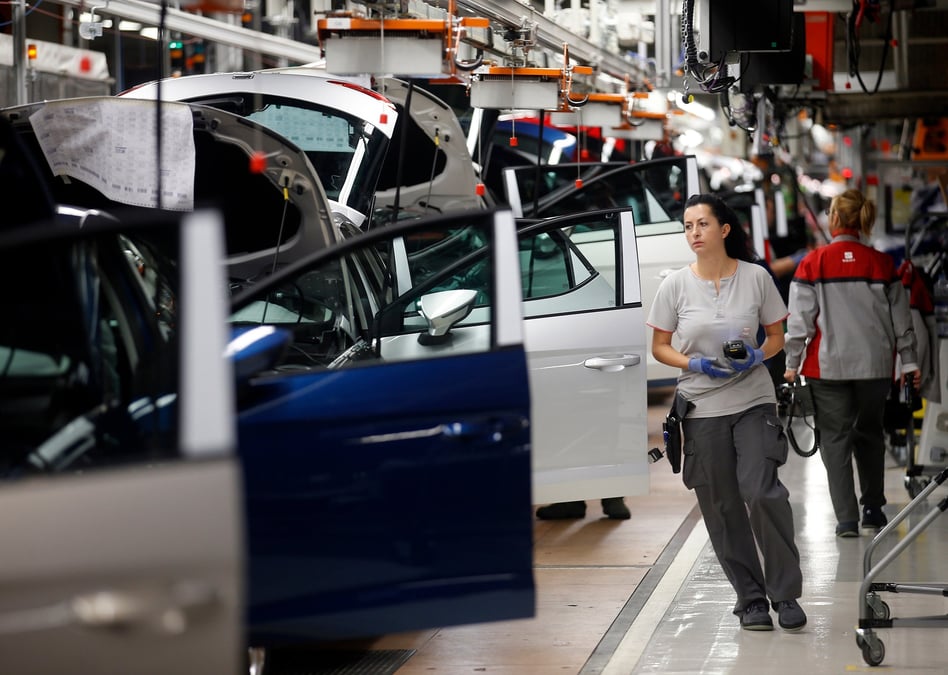 Des ouvriers assemblent des vehicules sur une chaine de montage