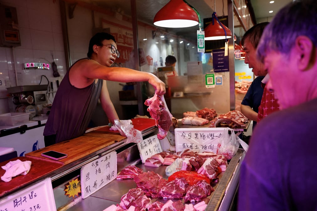 Un vendeur de porc s'occupe d'un client sur un marche matinal a pekin