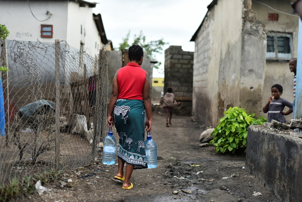 Une femme arrose dans un quartier touche par l’epidemie de cholera a lusaka, en zambie