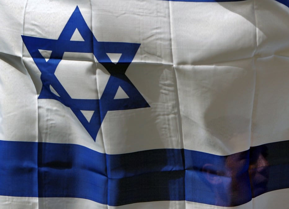 Un israelien tient le drapeau d'israel dans la ville de shfaram