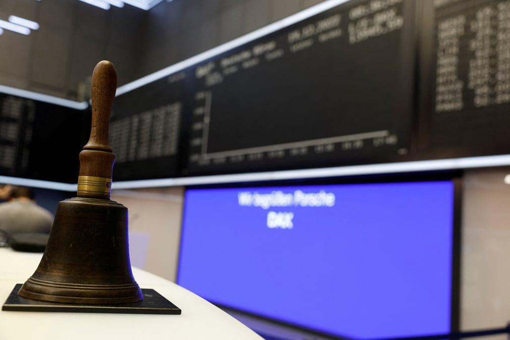 Photo d'une cloche qui est placee devant un ecran de l'indice allemand dax a la bourse de francfort