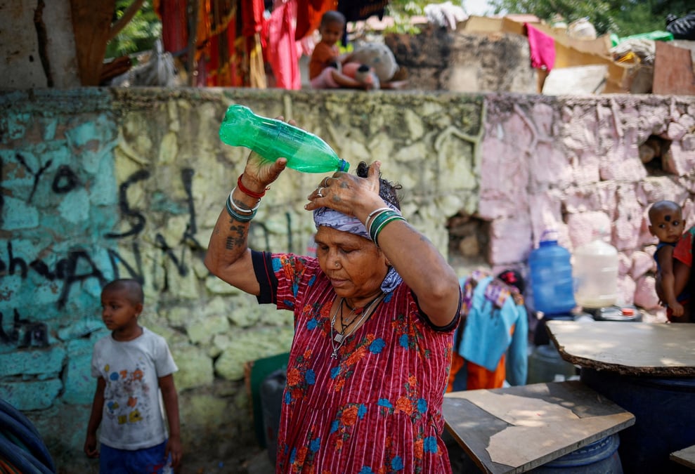 Une femme se verse de l'eau sur la tete lors d'une journee chaude a new delhi