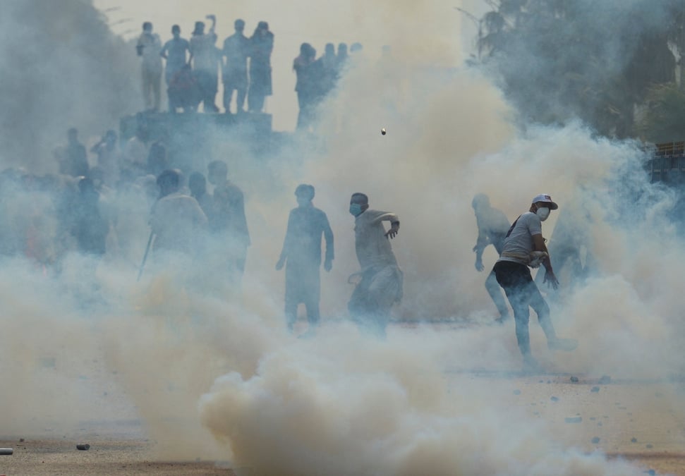A supporter of jailed former pakistani pm imran khan's party throws back a tear gas shell during an anti-government rally in islamabad
