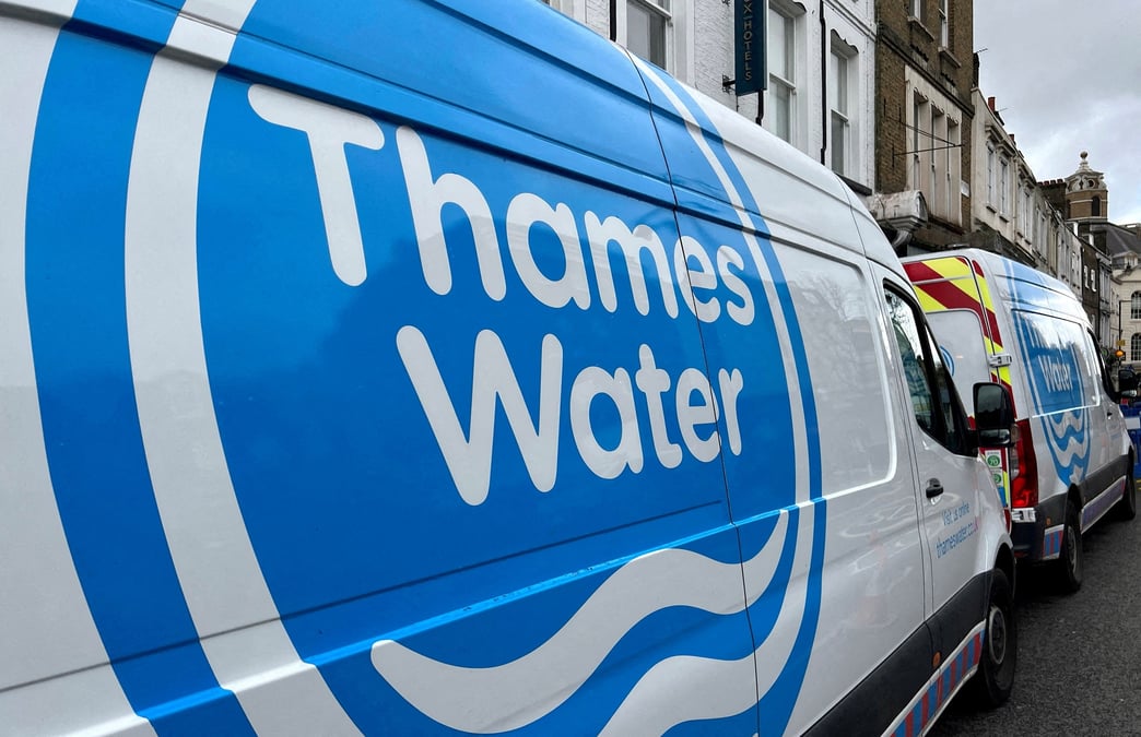 Des camionnettes de thames water sont garees sur une route a londres