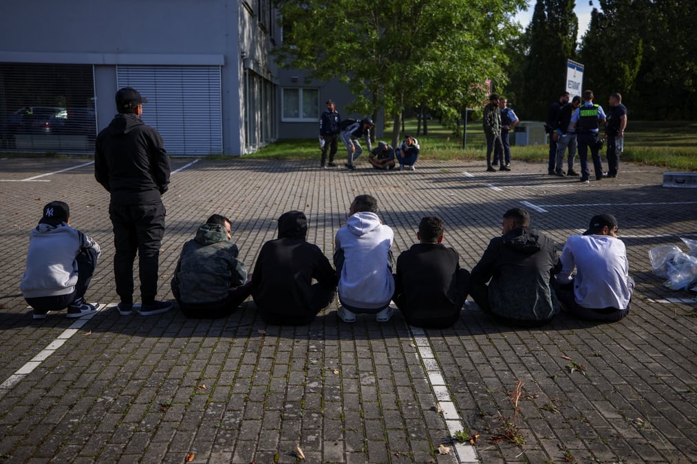 Des migrants sont assis par terre apres avoir ete arretes par la police allemande