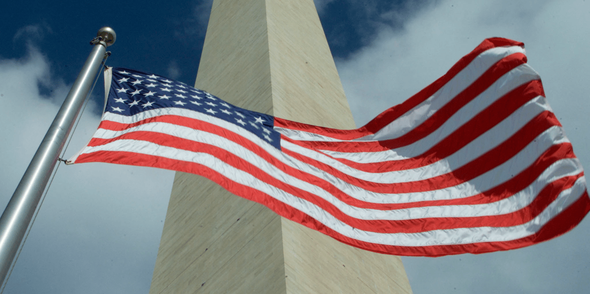 Le drapeau americain flottant devant le washington monument