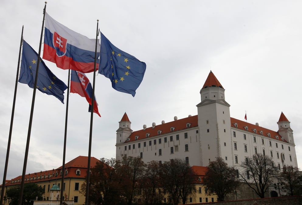 Les drapeaux de la slovaquie et de l'union europeenne flottent a cote du chateau de bratislava