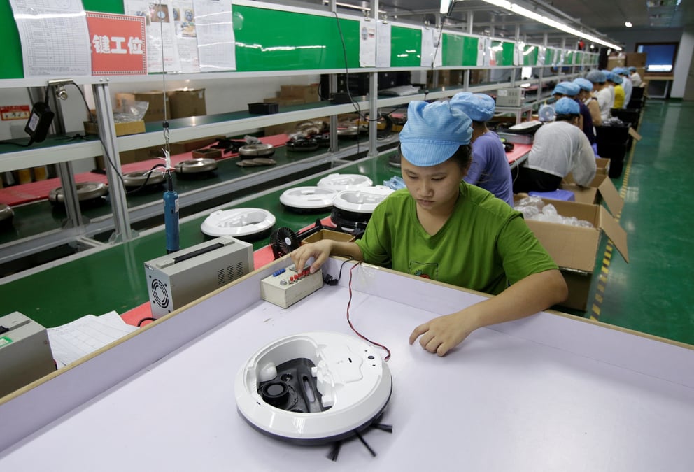 Photo d'archives: une employee travaille sur la ligne de production d'une usine d'aspirateurs robots de matsutek a shenzhen