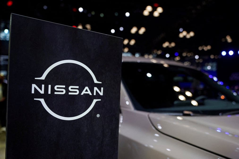 Un logo nissan est visible a cote d'un vehicule lors du salon international de l'automobile de new york