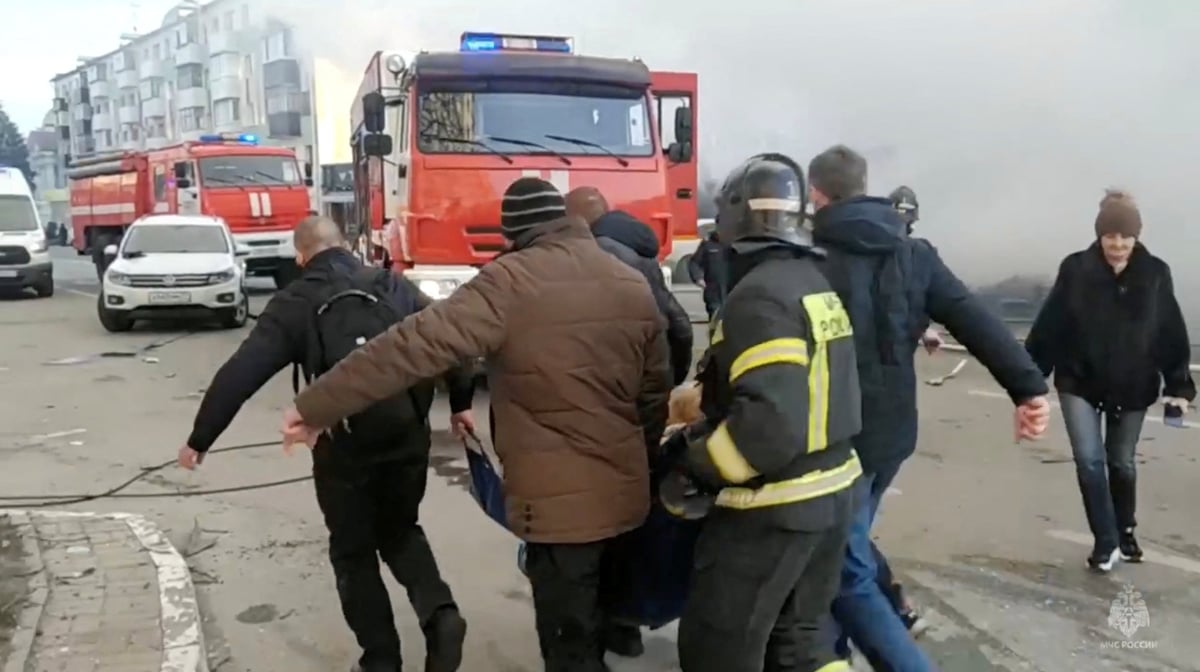 Des personnes, dont des pompiers, transportent une personne hors du site apres un bombardement a belgorod