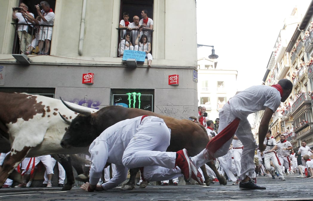 Trois hommes encornes par des taureaux a pampelune
