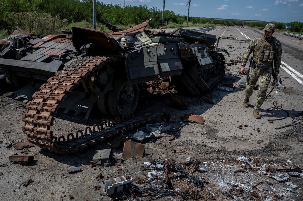 Un militaire ukrainien marche pres d’un char detruit