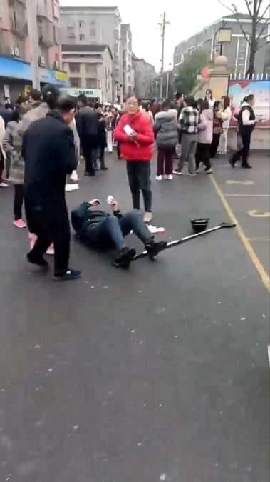 Une personne git au sol apres une collision de vehicule devant une ecole primaire en chine