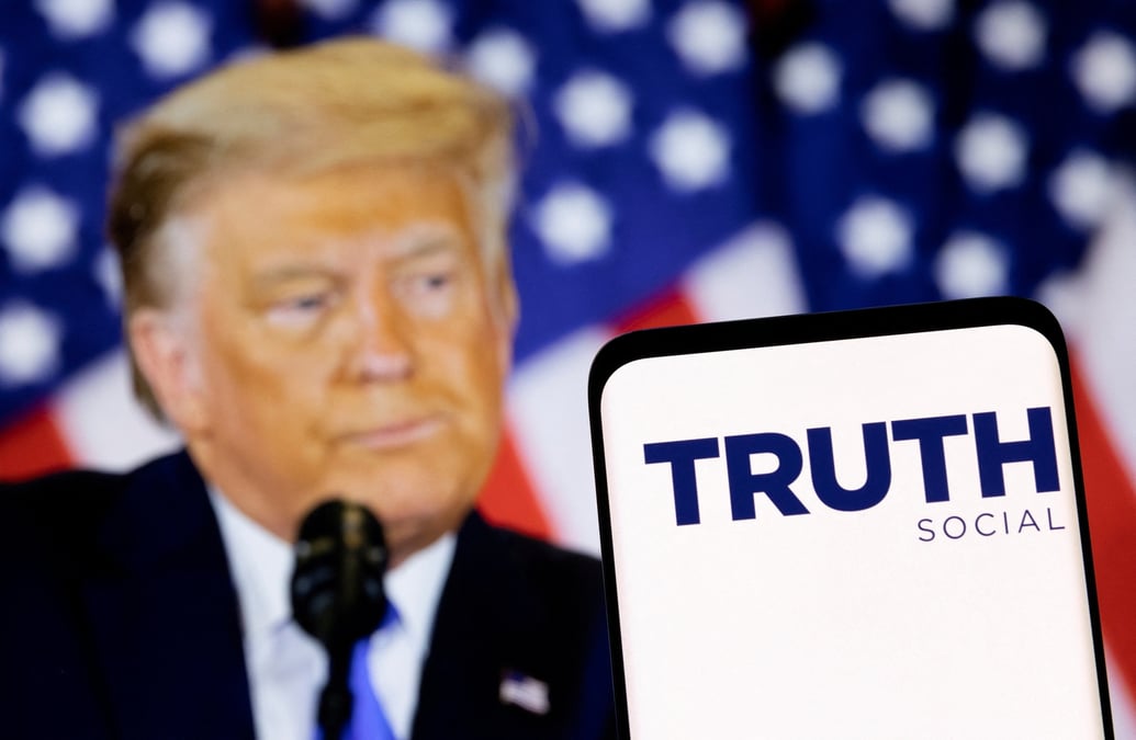 Le logo du reseau social truth est visible sur un smartphone devant une image de donald trump