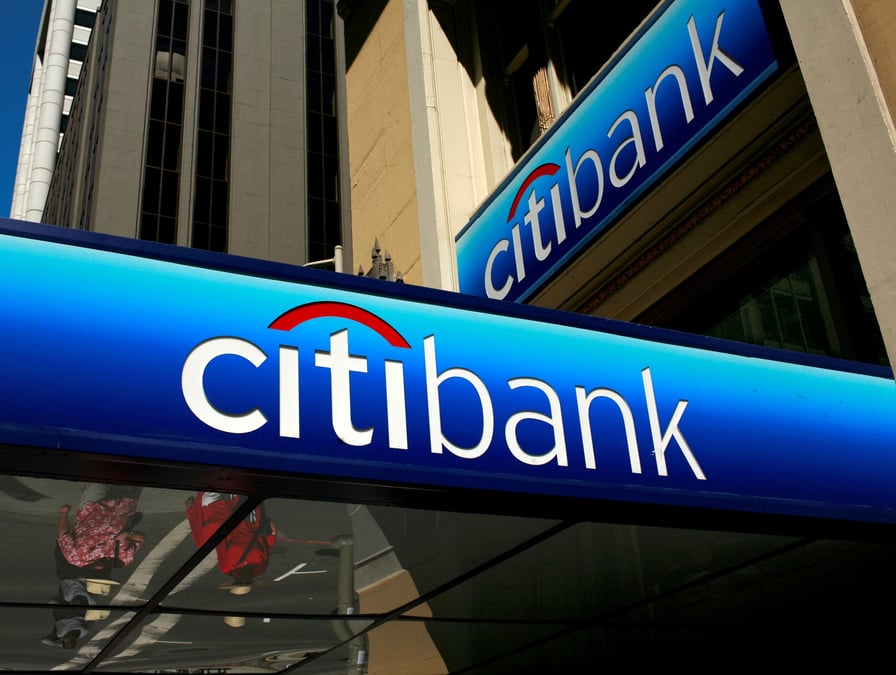 Des personnes marchent sous le logo d'une succursale de la citibank dans le quartier financier de san francisco, en californie