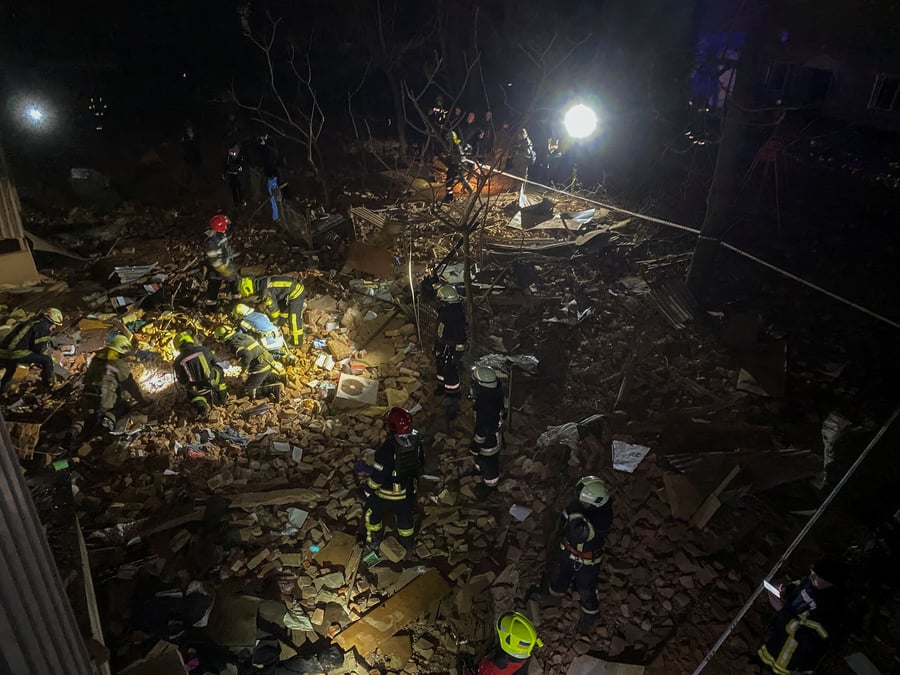 Des pompiers ukrainiens travaillent sur le site d'un immeuble d'habitation gravement endommage par un tir de missile russe a kharkov