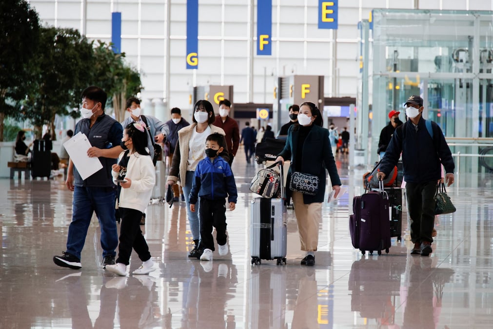 Des personnes portant des masques faciaux pour eviter de contracter la maladie du coronavirus (covid-19) marchent a l'aeroport international d'incheon, en coree du sud